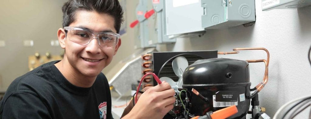 A Summit College HVAC student learning hands-on with real tools.