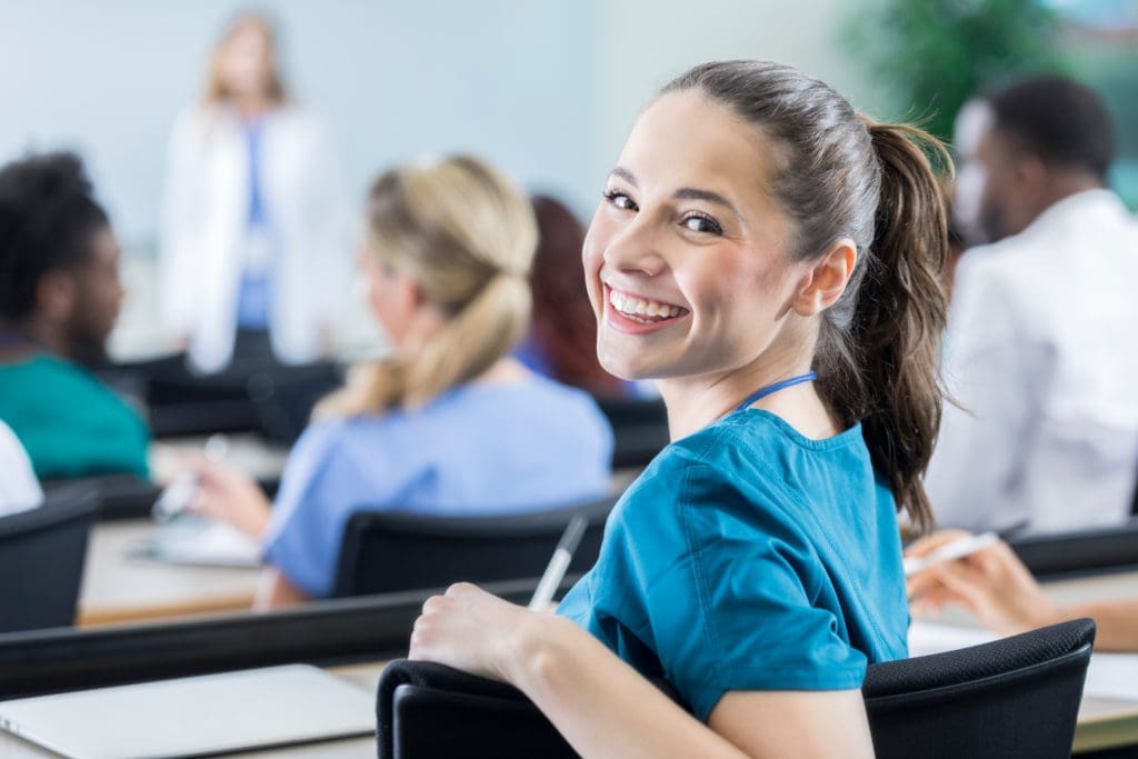 Cheerful female medical student in the classroom learning about CNA